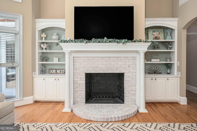 395 Grove Ridge Dr, Loganville, GA 30052 - detailed view of wood finished floors, a fireplace, baseboards, and arched walkways