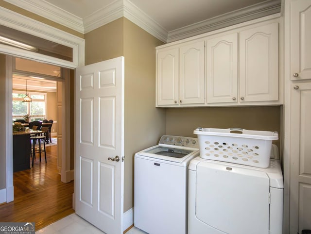 395 Grove Ridge Dr, Loganville, GA 30052 - laundry area with cabinet space, washing machine and clothes dryer, ornamental molding, light wood-style floors, and a chandelier