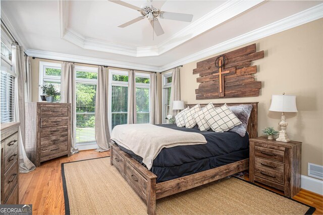 395 Grove Ridge Dr, Loganville, GA 30052 - bedroom with light wood-type flooring, ornamental molding, a tray ceiling, and ceiling fan