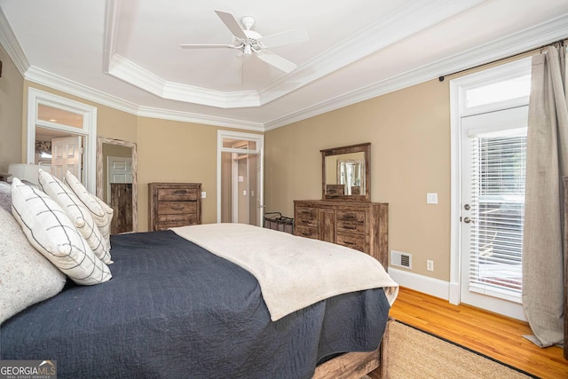 395 Grove Ridge Dr, Loganville, GA 30052 - bedroom with a tray ceiling, light wood-style floors, crown molding, access to outside, and a ceiling fan