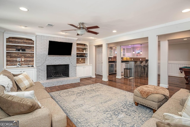 395 Grove Ridge Dr, Loganville, GA 30052 - living area featuring ornamental molding, ceiling fan, wood finished floors, a brick fireplace, and built in features