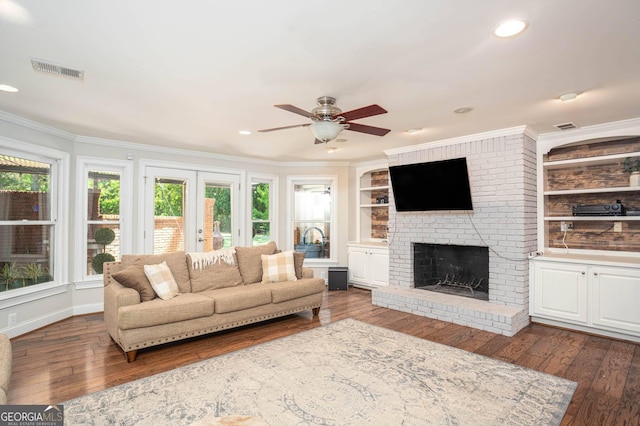 395 Grove Ridge Dr, Loganville, GA 30052 - living area with a ceiling fan, a fireplace, wood-type flooring, crown molding, and built in shelves