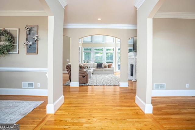 395 Grove Ridge Dr, Loganville, GA 30052 - foyer featuring arched walkways, crown molding, light wood finished floors, a fireplace, and recessed lighting