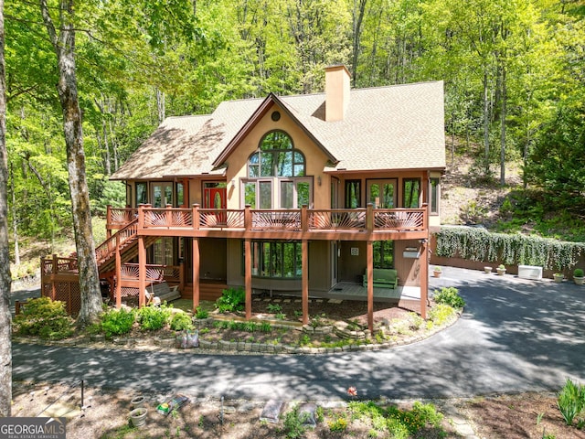 1289 Rainwater Trl, Tiger, GA 30576 - rustic home with roof with shingles, a chimney, a deck, stairway, and a view of trees
