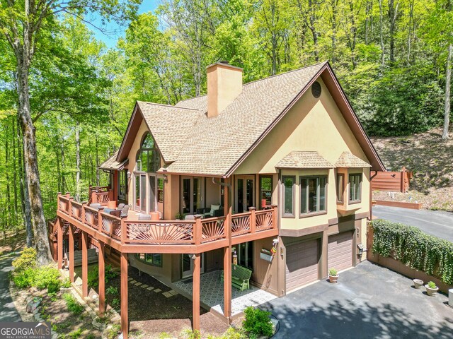 1289 Rainwater Trl, Tiger, GA 30576 - back of house featuring a chimney, asphalt driveway, stucco siding, and a garage