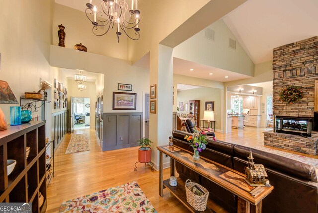 1289 Rainwater Trl, Tiger, GA 30576 - living room featuring high vaulted ceiling, a chandelier, light wood-style flooring, and a fireplace