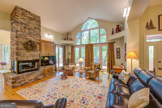 1289 Rainwater Trl, Tiger, GA 30576 - living area featuring high vaulted ceiling, light wood-style flooring, and a stone fireplace