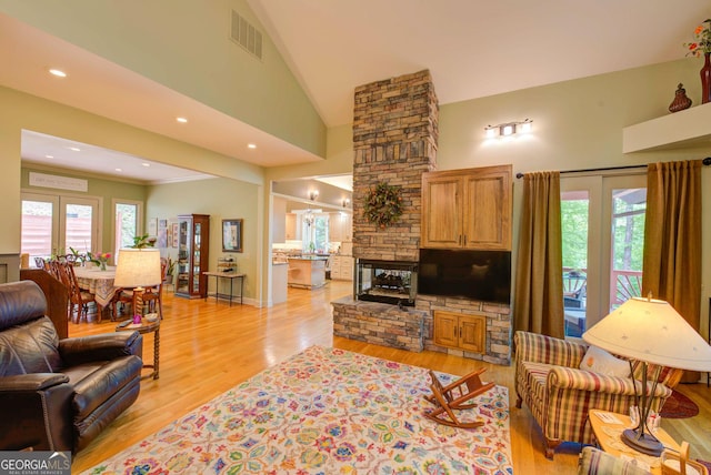 1289 Rainwater Trl, Tiger, GA 30576 - living room featuring plenty of natural light, light wood finished floors, high vaulted ceiling, a fireplace, and recessed lighting