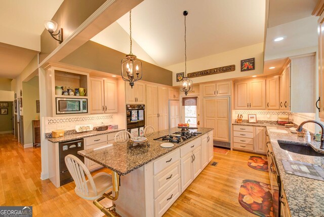 1289 Rainwater Trl, Tiger, GA 30576 - kitchen featuring a sink, stainless steel microwave, a center island, gas cooktop, and backsplash