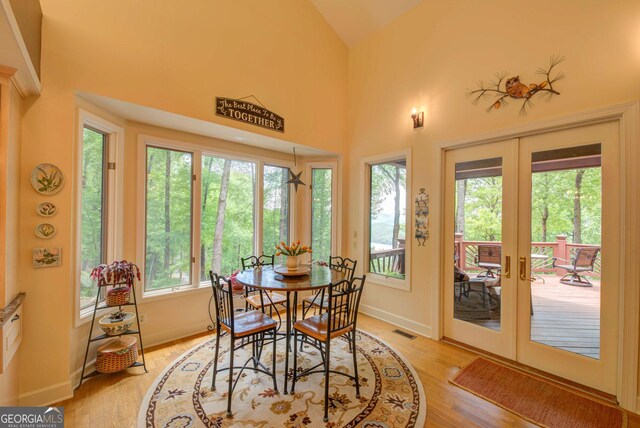 1289 Rainwater Trl, Tiger, GA 30576 - dining area featuring french doors, light wood finished floors, lofted ceiling, and baseboards