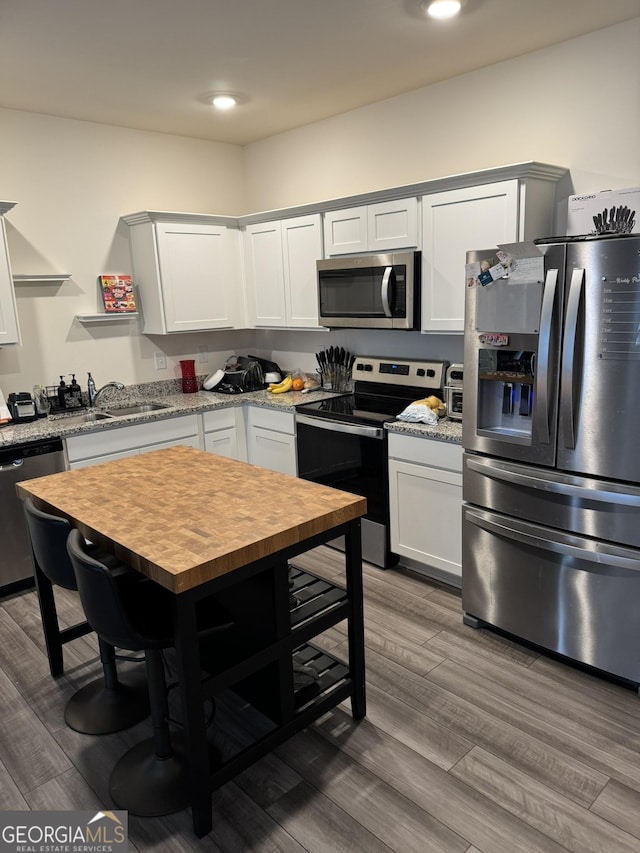 536 Magnolia Cir Unit 116, Palmetto, GA 30268 - kitchen with appliances with stainless steel finishes, wooden counters, a sink, recessed lighting, and wood finished floors