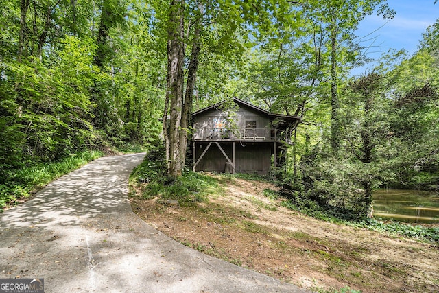 74 Charity Ln, Clayton, GA 30525 - view of front of property featuring a wooden deck, a forest view, and driveway