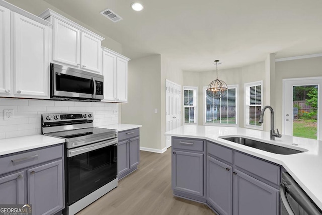 6341 Stewart Ridge Walk, Buford, GA 30518 - kitchen featuring appliances with stainless steel finishes, a sink, gray cabinets, light wood-style flooring, and recessed lighting