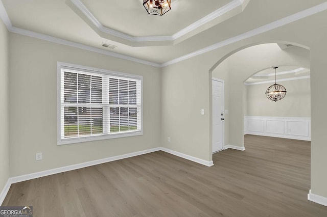 6341 Stewart Ridge Walk, Buford, GA 30518 - empty room with a raised ceiling, a chandelier, wood finished floors, arched walkways, and crown molding