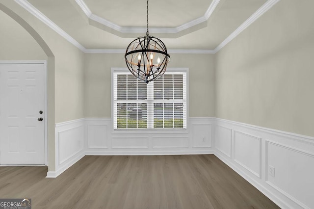 6341 Stewart Ridge Walk, Buford, GA 30518 - unfurnished dining area featuring a raised ceiling, wood finished floors, a chandelier, arched walkways, and a wainscoted wall