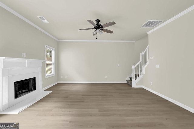 6341 Stewart Ridge Walk, Buford, GA 30518 - unfurnished living room featuring crown molding, a ceiling fan, light wood-style flooring, stairs, and a fireplace with raised hearth