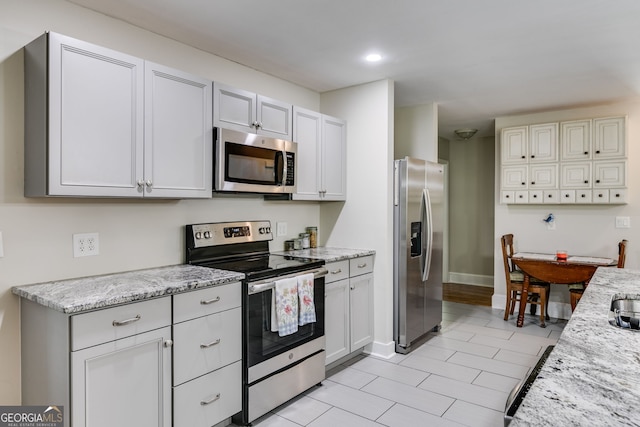 103 Depot St, Buchanan, GA 30113 - kitchen with stainless steel appliances, light stone counters, baseboards, recessed lighting, and light tile patterned floors