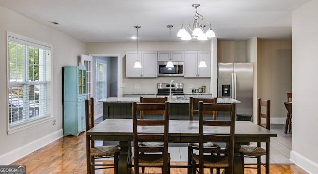 103 Depot St, Buchanan, GA 30113 - dining area featuring a chandelier, baseboards, and light wood finished floors