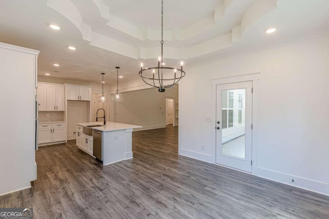 4075 O Henry Ct, Mcdonough, GA 30252 - kitchen with open floor plan, stainless steel dishwasher, dark wood finished floors, a chandelier, and white cabinets