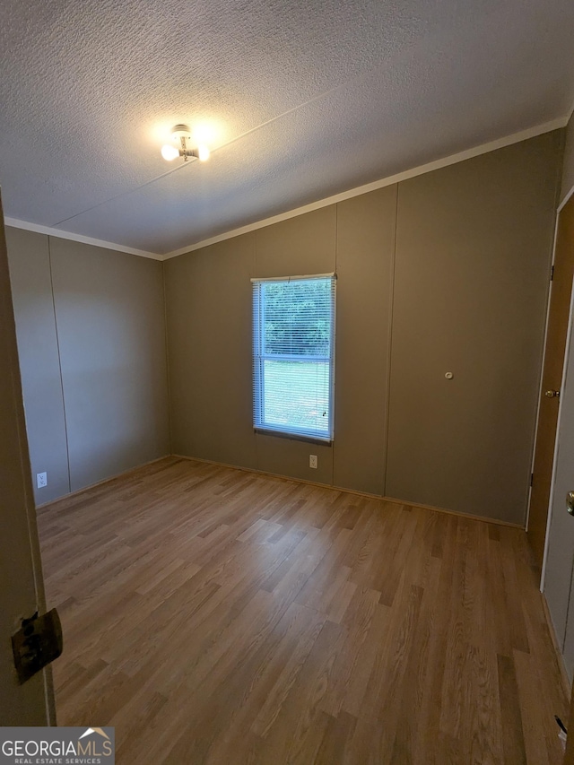 1096 Tesnatee Gap Valley Rd, Cleveland, GA 30528 - unfurnished room with ornamental molding, wood finished floors, vaulted ceiling, and a textured ceiling