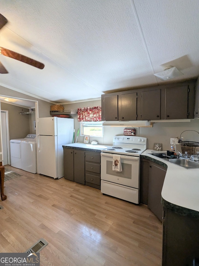 1096 Tesnatee Gap Valley Rd, Cleveland, GA 30528 - kitchen featuring white appliances, separate washer and dryer, light wood-type flooring, vaulted ceiling, and light countertops