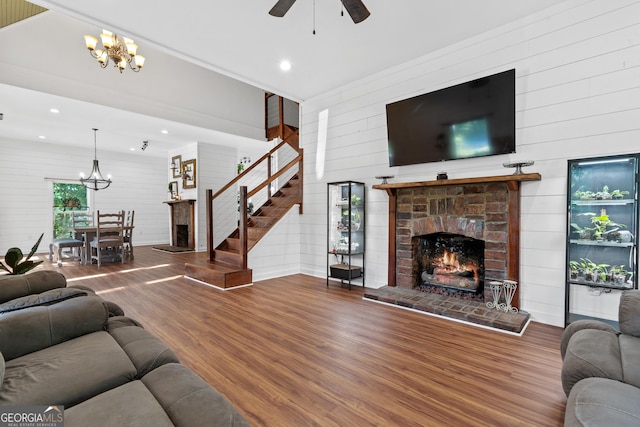 7170 Church St, Bartow, GA 30413 - living area with a chandelier, a brick fireplace, wood finished floors, stairs, and a ceiling fan