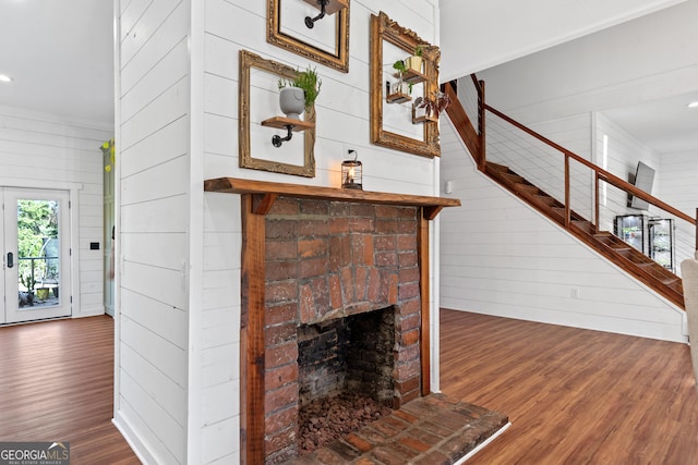 7170 Church St, Bartow, GA 30413 - unfurnished living room with wood finished floors, stairs, wooden walls, a fireplace, and recessed lighting