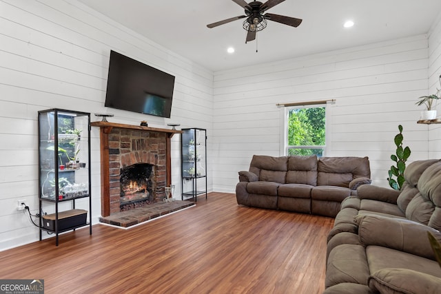 7170 Church St, Bartow, GA 30413 - living room with wood finished floors, a ceiling fan, wood walls, recessed lighting, and a fireplace