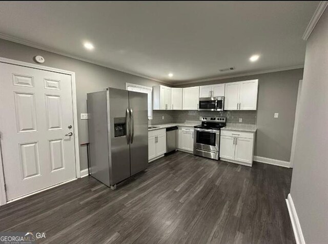 5711 Sterling Pl, Macon, GA 31206 - kitchen with stainless steel appliances, crown molding, light countertops, dark wood-style floors, and tasteful backsplash