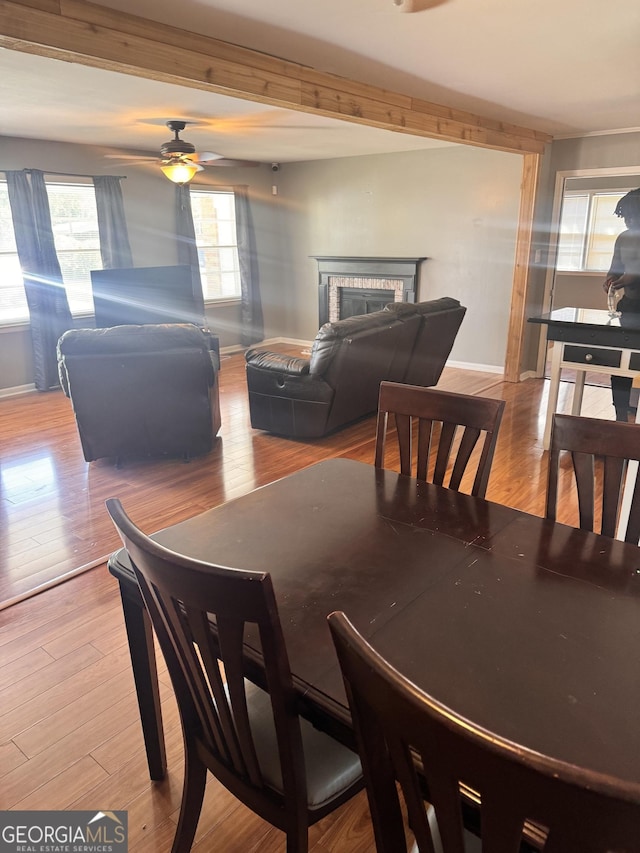206 Audubon Way, Warner Robins, GA 31088 - dining area with a fireplace, baseboards, ceiling fan, and wood finished floors