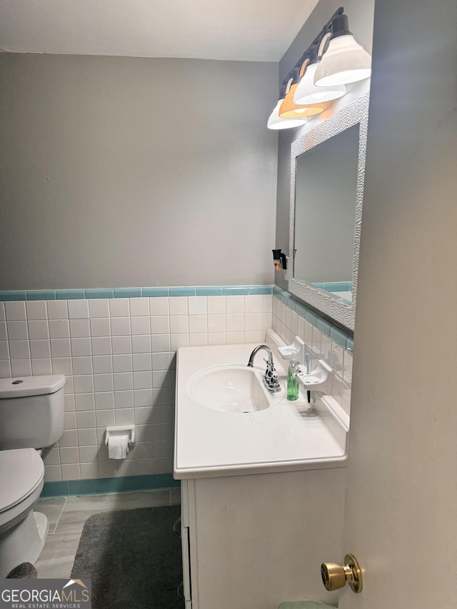 206 Audubon Way, Warner Robins, GA 31088 - half bathroom featuring tile walls, vanity, toilet, wainscoting, and wood finished floors