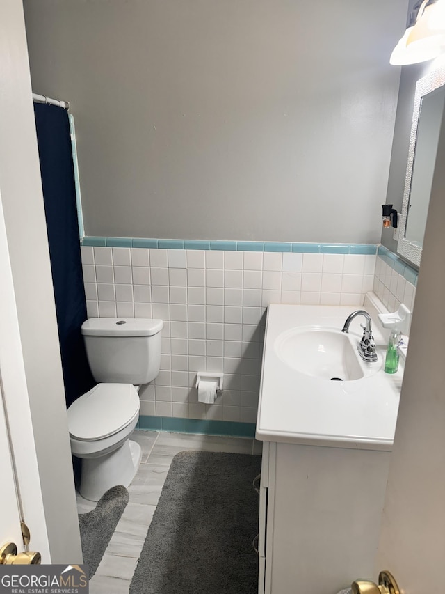 206 Audubon Way, Warner Robins, GA 31088 - full bath with tile walls, toilet, vanity, a wainscoted wall, and wood finished floors