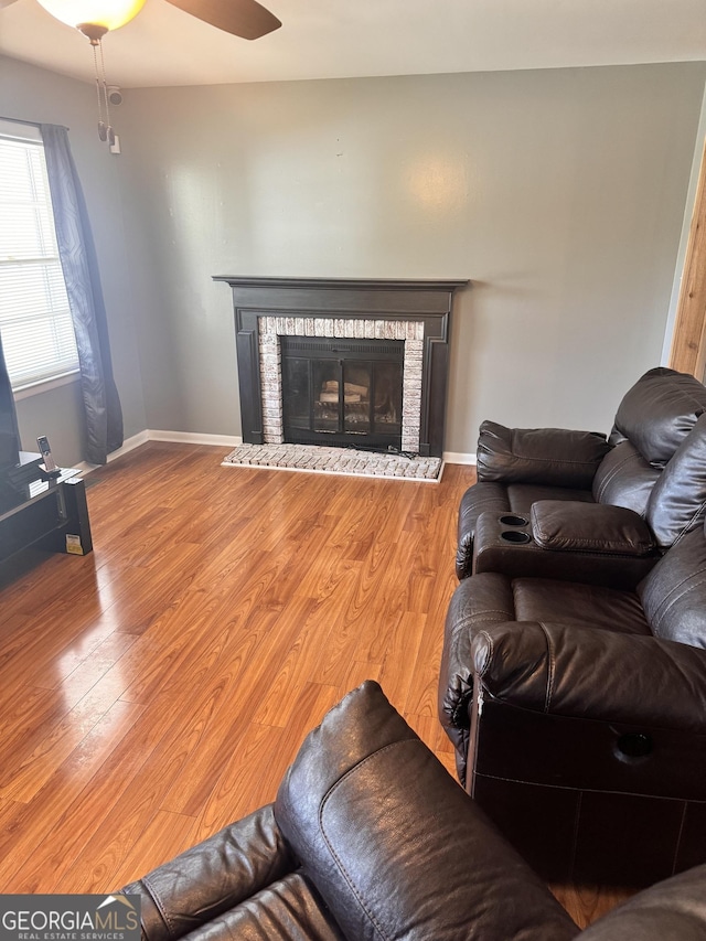 206 Audubon Way, Warner Robins, GA 31088 - living area with a brick fireplace, wood finished floors, ceiling fan, and baseboards