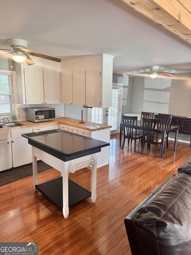 206 Audubon Way, Warner Robins, GA 31088 - kitchen featuring ceiling fan, stainless steel microwave, decorative backsplash, a sink, and wood finished floors