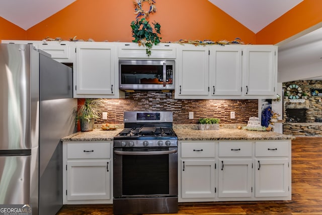 894 Lake Circle Rd, Buchanan, GA 30113 - kitchen with stainless steel appliances, lofted ceiling, dark wood-style floors, and white cabinets