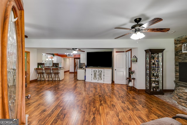 894 Lake Circle Rd, Buchanan, GA 30113 - living room featuring ceiling fan, wood finished floors, a fireplace, and baseboards