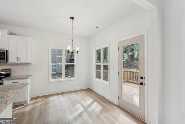 2279 Lakeview Pkwy, Villa Rica, GA 30180 - unfurnished dining area with light wood-style flooring, a chandelier, and baseboards
