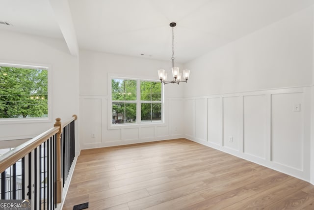 2279 Lakeview Pkwy, Villa Rica, GA 30180 - unfurnished room with a decorative wall, a chandelier, healthy amount of natural light, light wood finished floors, and wainscoting