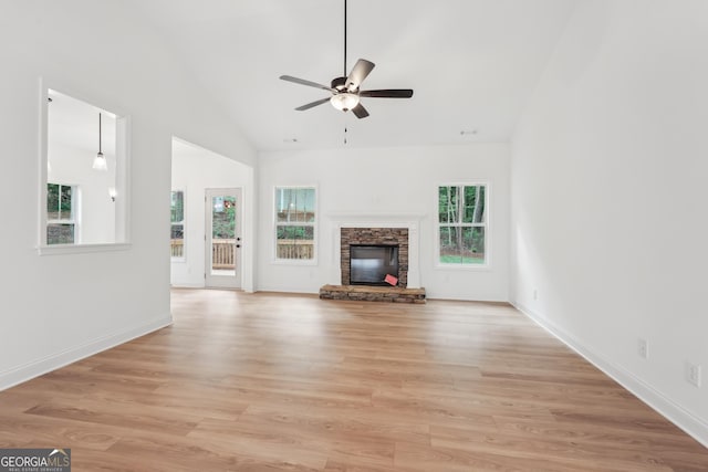 2279 Lakeview Pkwy, Villa Rica, GA 30180 - unfurnished living room with a ceiling fan, light wood-style flooring, a stone fireplace, high vaulted ceiling, and baseboards