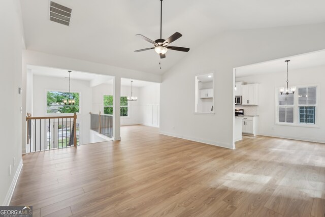 2279 Lakeview Pkwy, Villa Rica, GA 30180 - unfurnished living room with a chandelier, ceiling fan, light wood-style floors, lofted ceiling, and baseboards