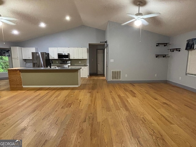 161 Cedar Cove Dr, Buckhead, GA 30625 - kitchen with ceiling fan, appliances with stainless steel finishes, lofted ceiling, white cabinetry, and a textured ceiling
