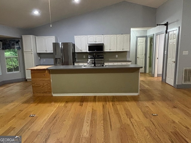 161 Cedar Cove Dr, Buckhead, GA 30625 - kitchen featuring appliances with stainless steel finishes, white cabinets, a sink, high vaulted ceiling, and light wood finished floors
