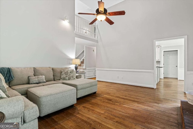 4381 Laurian Dr NW, Kennesaw, GA 30144 - living room with a towering ceiling, a ceiling fan, wood finished floors, and wainscoting