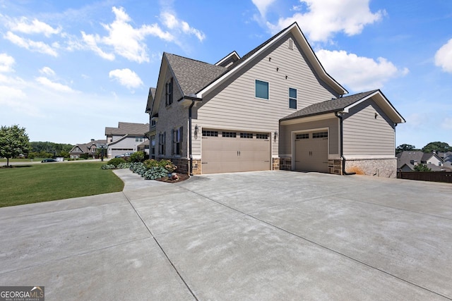1858 Switchgrass Dr, Statham, GA 30666 - view of property exterior with stone siding, a lawn, concrete driveway, roof with shingles, and an attached garage