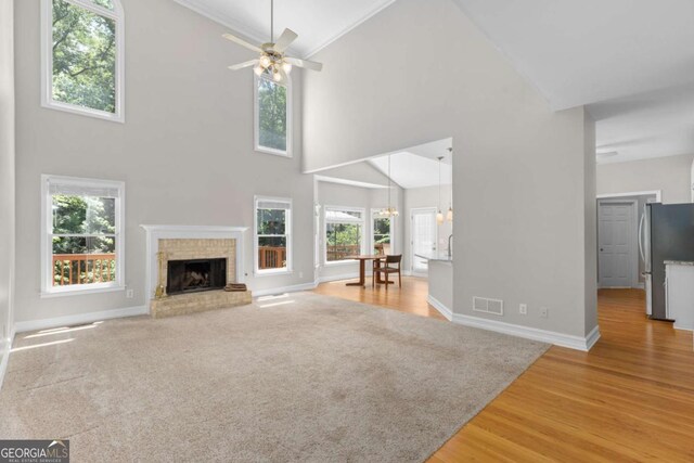 85 Arabian Ave, Alpharetta, GA 30004 - unfurnished living room with high vaulted ceiling, a ceiling fan, a fireplace, light wood-style flooring, and baseboards