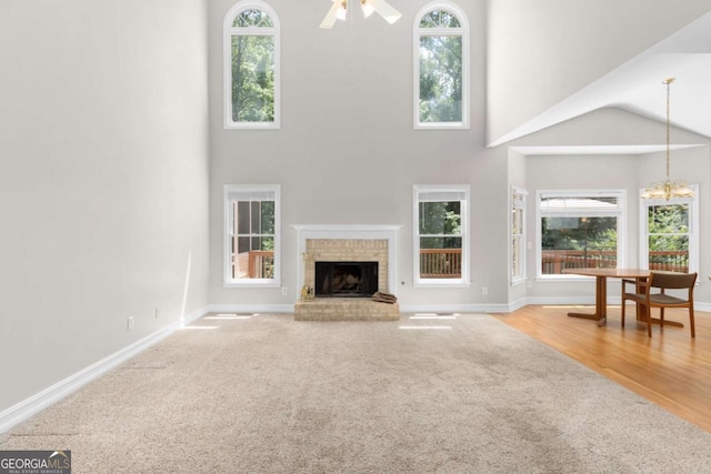 85 Arabian Ave, Alpharetta, GA 30004 - unfurnished living room with carpet, a towering ceiling, plenty of natural light, a fireplace, and ceiling fan