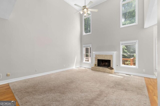 85 Arabian Ave, Alpharetta, GA 30004 - unfurnished living room featuring high vaulted ceiling, baseboards, ceiling fan, a brick fireplace, and wood finished floors