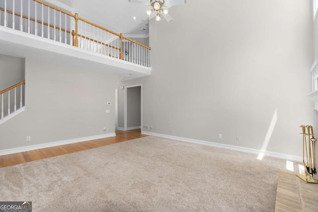 85 Arabian Ave, Alpharetta, GA 30004 - unfurnished living room with carpet floors, a high ceiling, ceiling fan, baseboards, and stairs