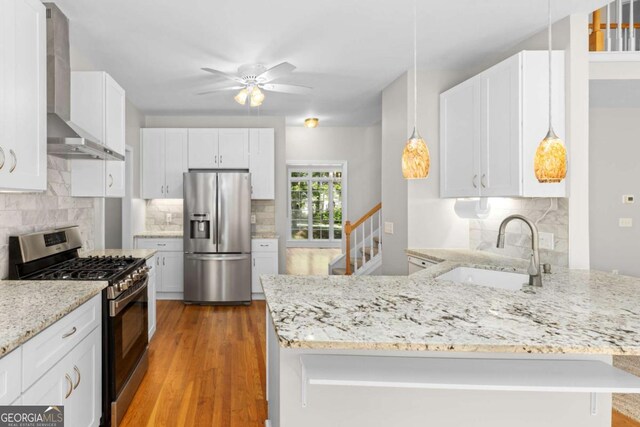 85 Arabian Ave, Alpharetta, GA 30004 - kitchen featuring appliances with stainless steel finishes, a sink, wall chimney exhaust hood, a peninsula, and ceiling fan