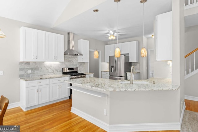85 Arabian Ave, Alpharetta, GA 30004 - kitchen featuring stainless steel appliances, wall chimney exhaust hood, light wood-type flooring, and decorative backsplash